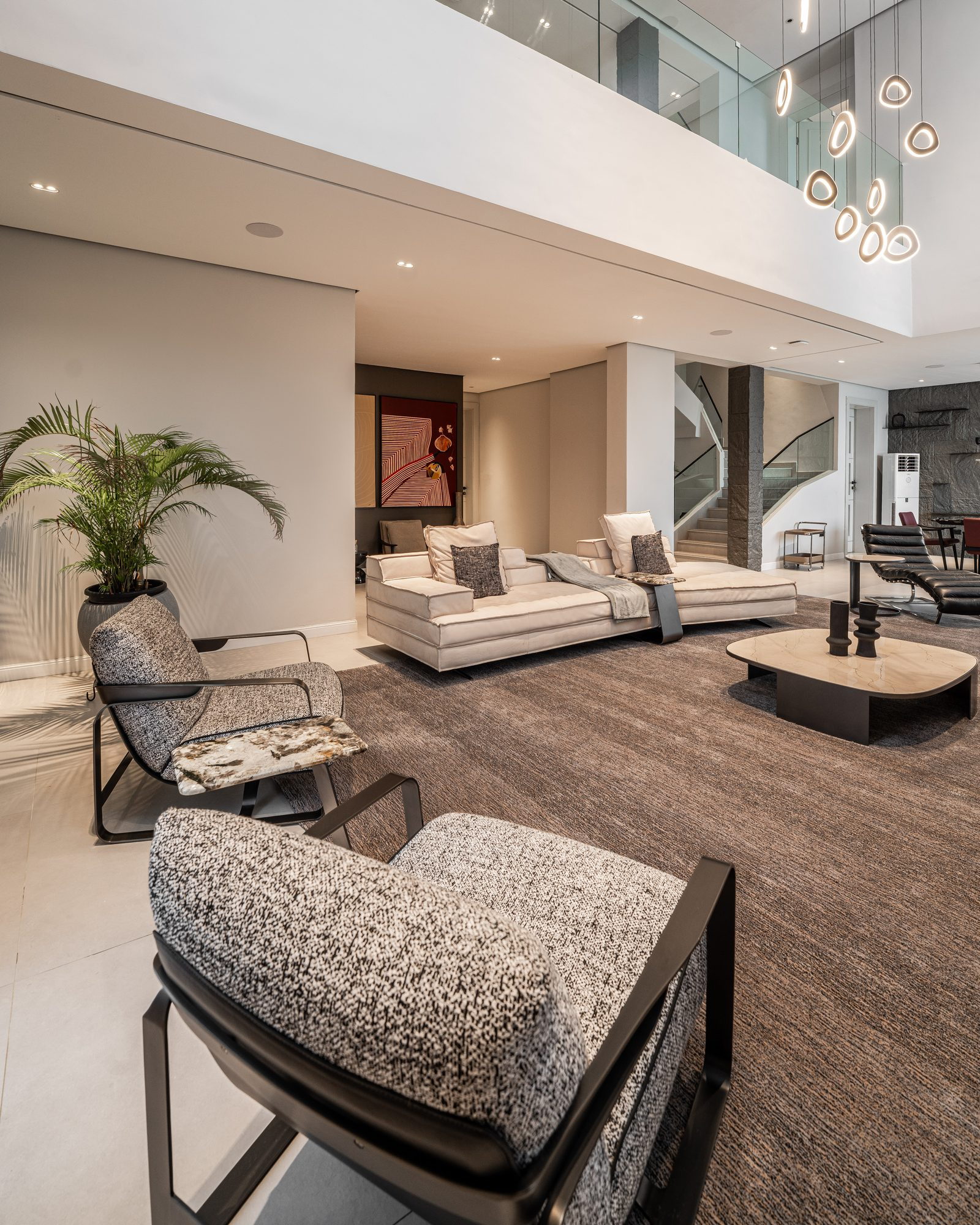 Linen sofa and a ribbed stone sculpture under the double-height void