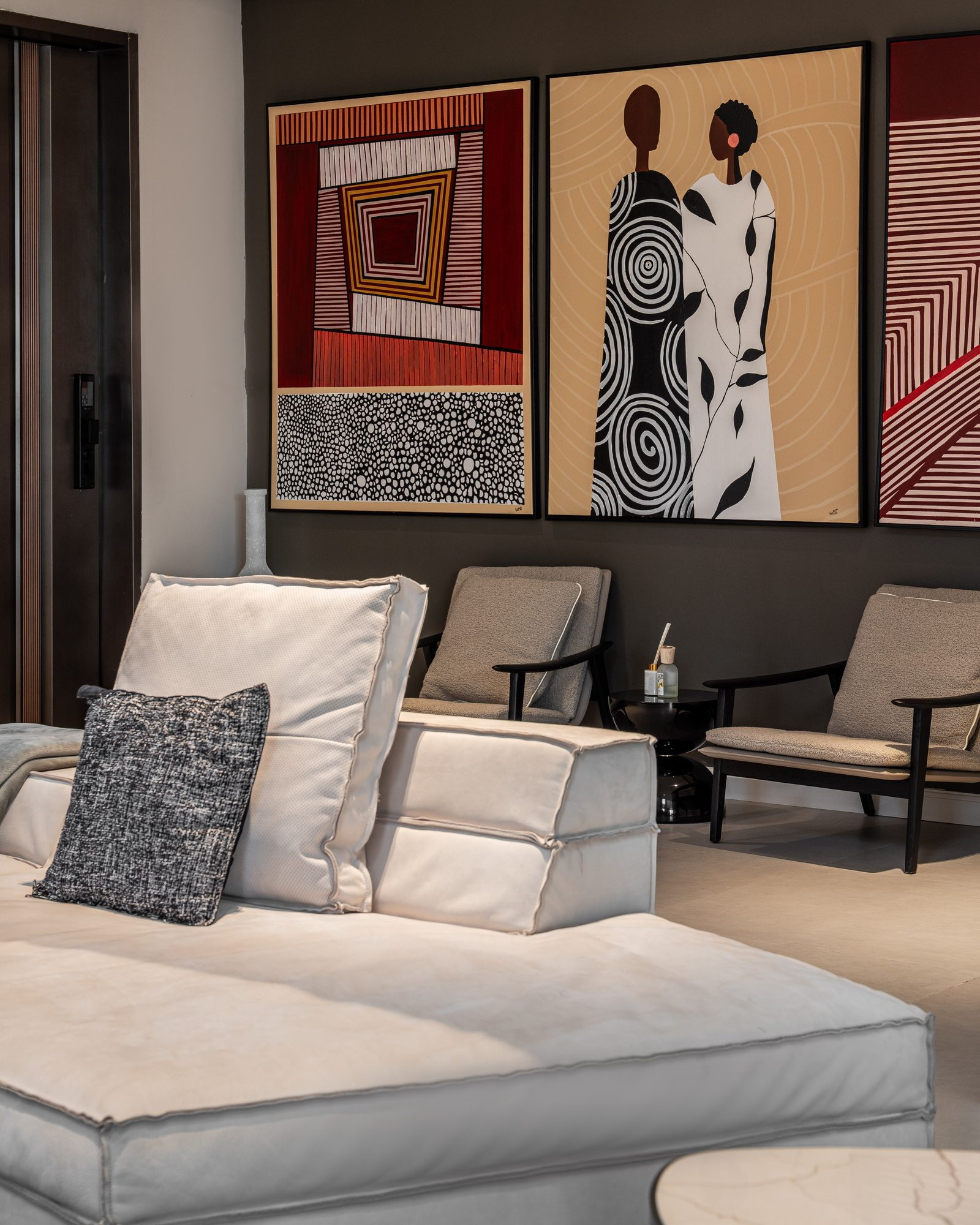 Sitting room: a low modular sofa beneath a triptych of contemporary African art