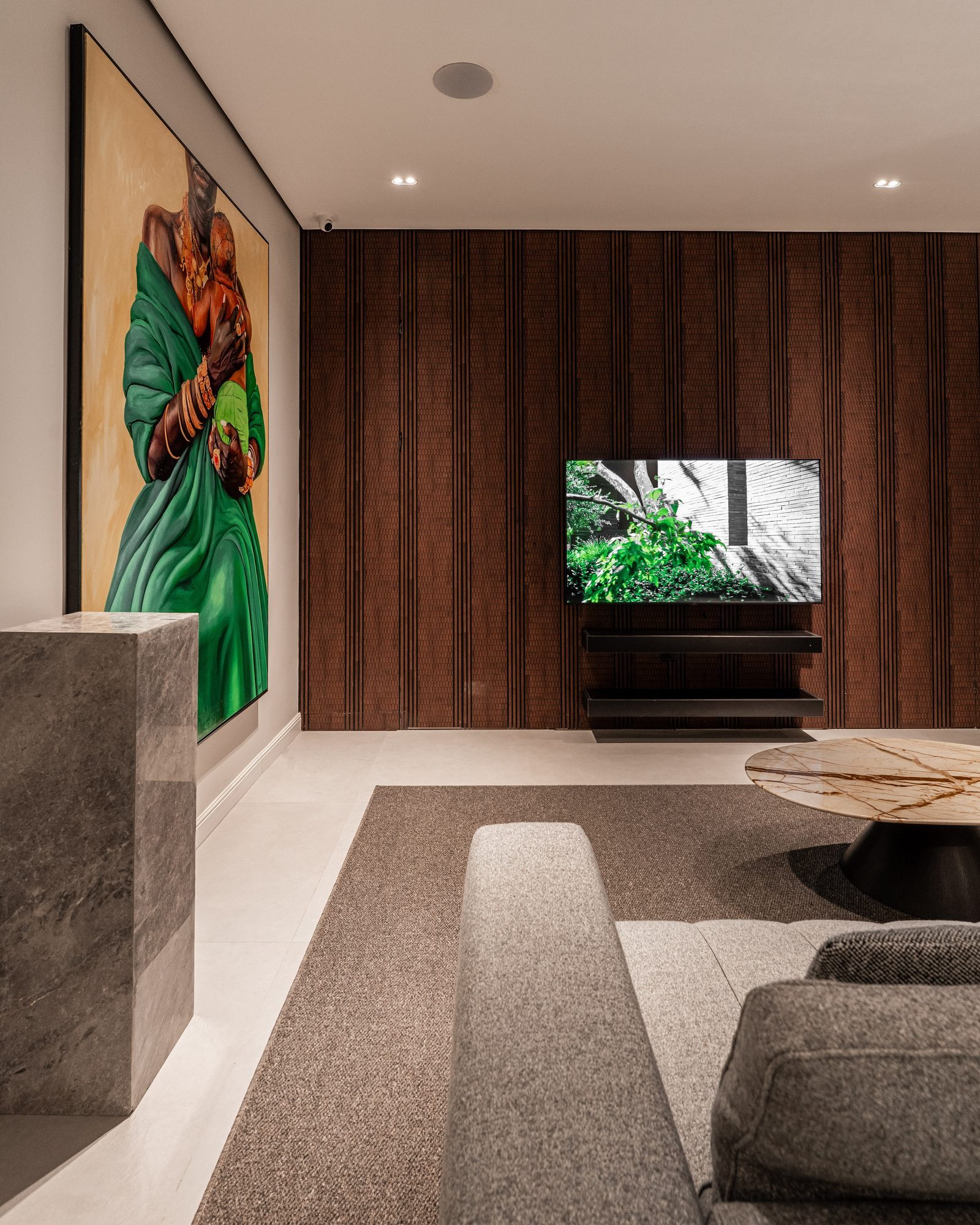 Media lounge: a wall of vertical timber slats, a green painting and a grey sectional