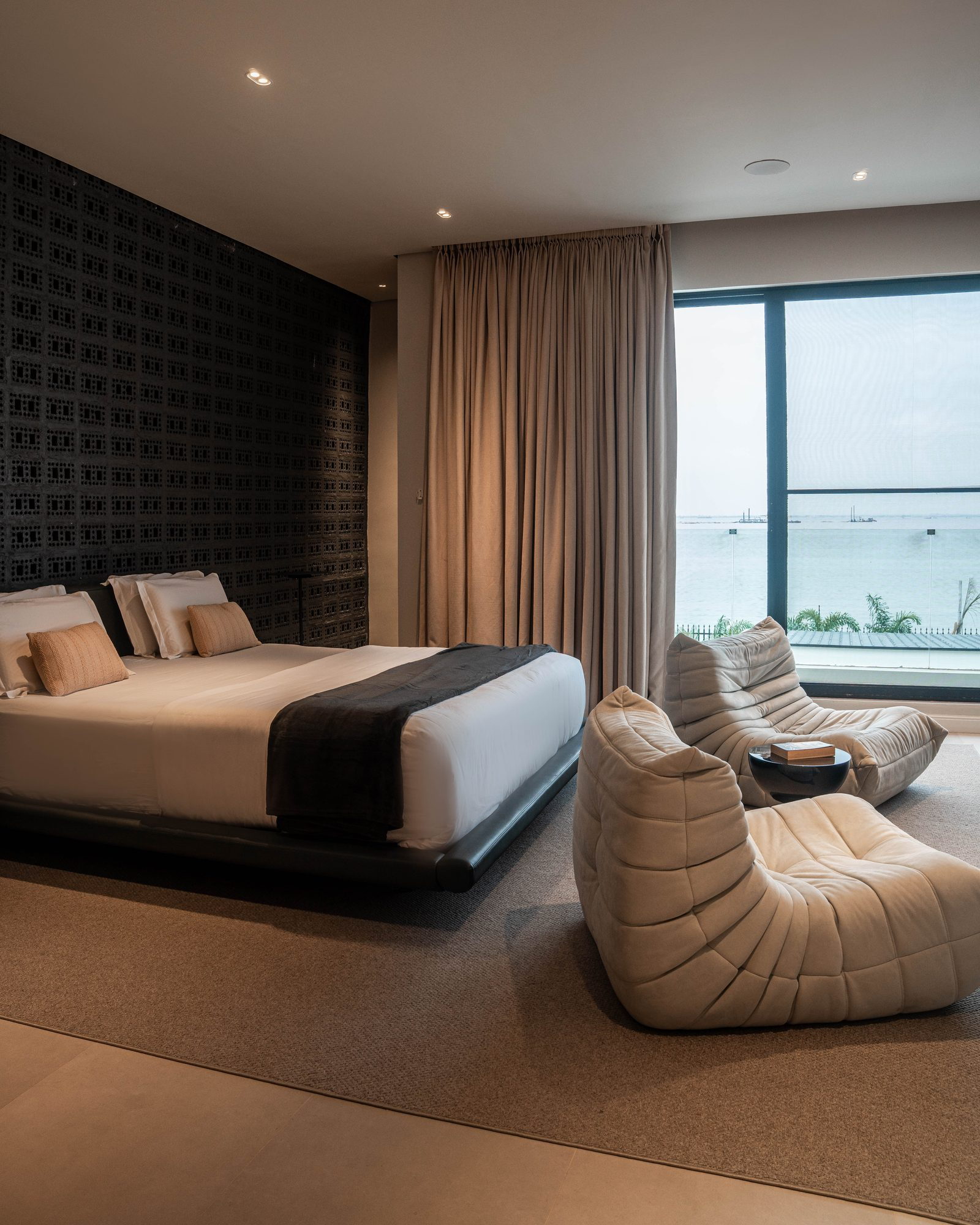 Principal bedroom: a floating bed, two Togo-style loungers and the sea beyond the window