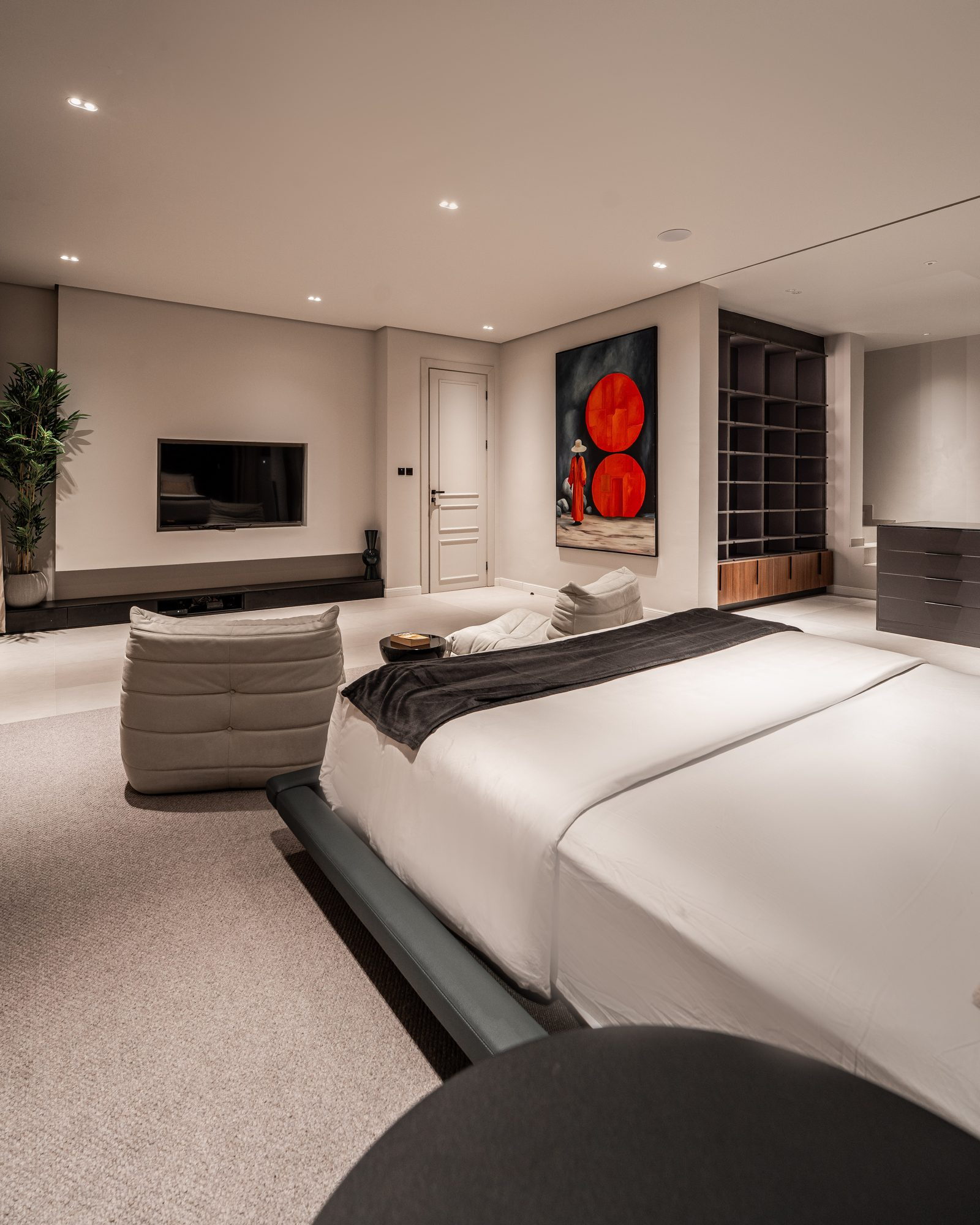 A red abstract canvas beside the bed